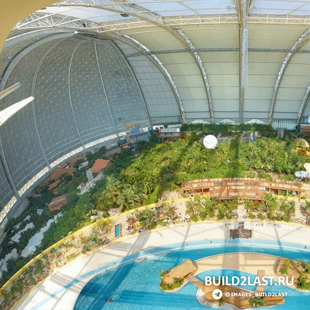 Азиатский стиль в аквапарке Tropical Islands с бассейном, бунгало и фонтаном, Германия Бассейн с фонтаном и бунгало в азиатском стиле в аквапарке с травяной крышей и колоннами в Германии